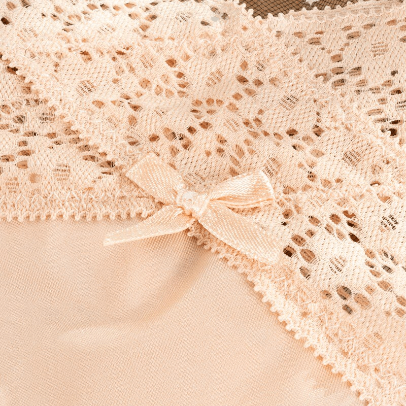 Close-up of lace detailing on sexy breathable women's thong with cutouts; beige color with delicate bow embellishment.